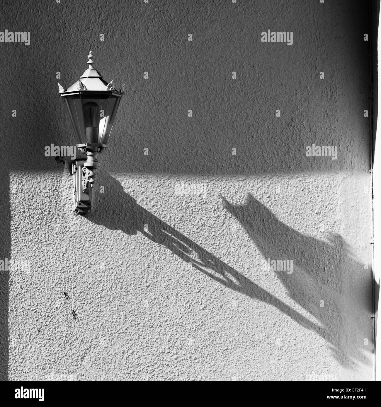 Lampada creando un'ombra su un muro di una casa. Foto Stock