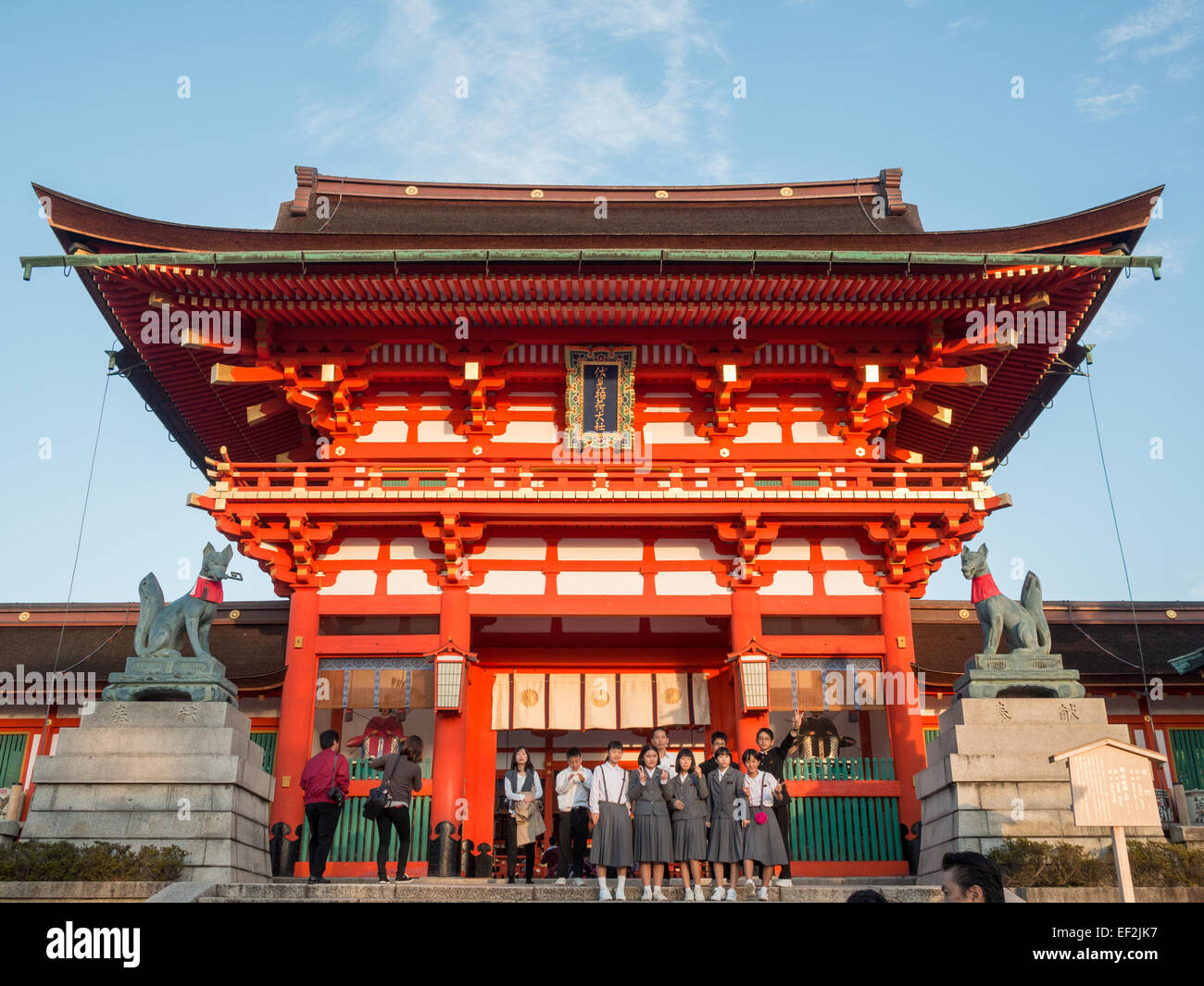 Studenti giapponesi gruppo di scattare una foto di fronte a Fushimi-Inari Taisha tempio edificio principale Foto Stock