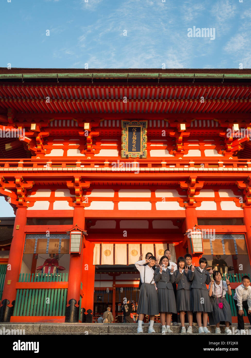 Studenti giapponesi gruppo di scattare una foto di fronte a Fushimi-Inari Taisha tempio edificio principale Foto Stock