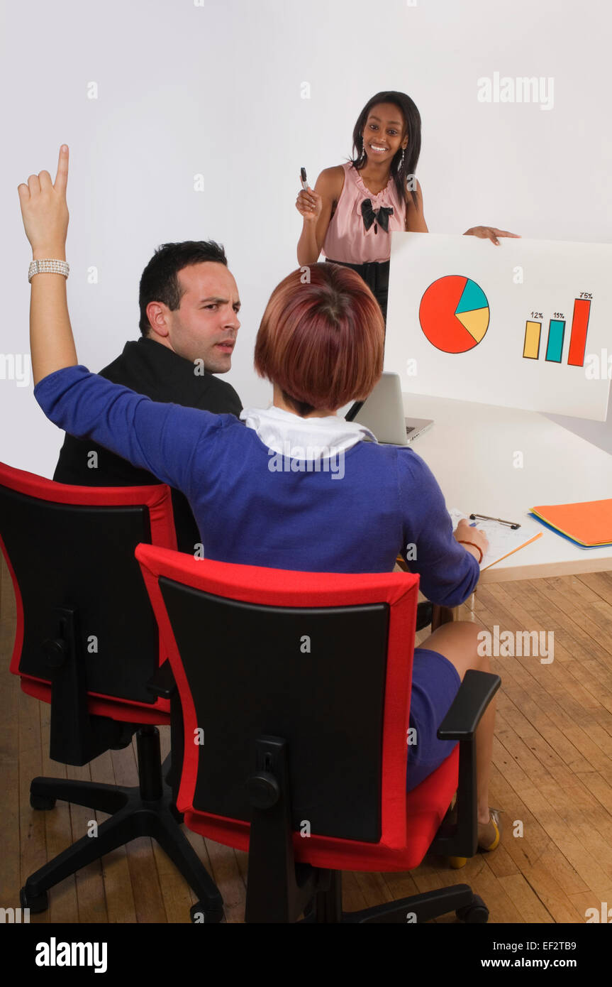 Imprenditrice ponendo una domanda durante una presentazione di office Foto Stock