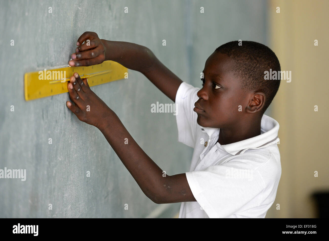 La pupilla, 10 anni, risolvendo una geometria assegnazione a lavagna, Basile Moreau Scuola, Carrefour, Port-au-Prince Foto Stock