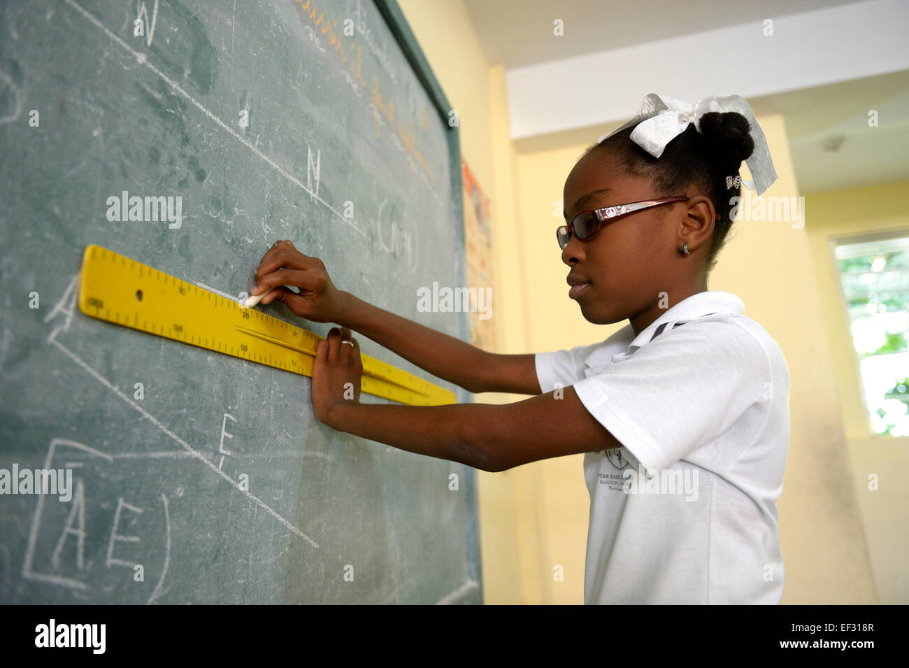 La scolaretta, 10 anni, risolvendo una geometria assegnazione a lavagna, Basile Moreau Scuola, Carrefour, Port-au-Prince Foto Stock