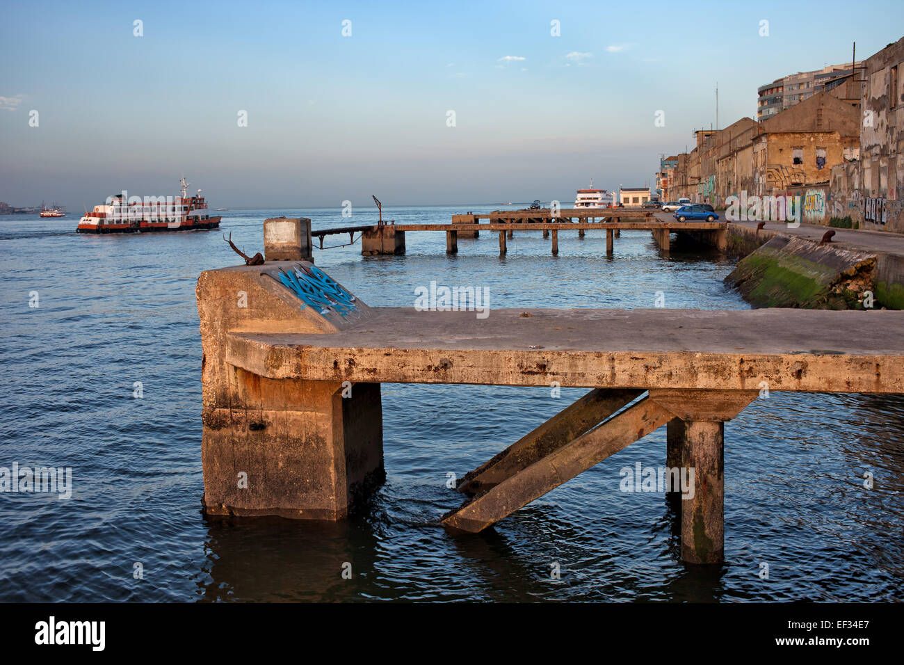 Vecchia banchina waterfront con pontili sul fiume Tejo a Almada, Portogallo. Foto Stock