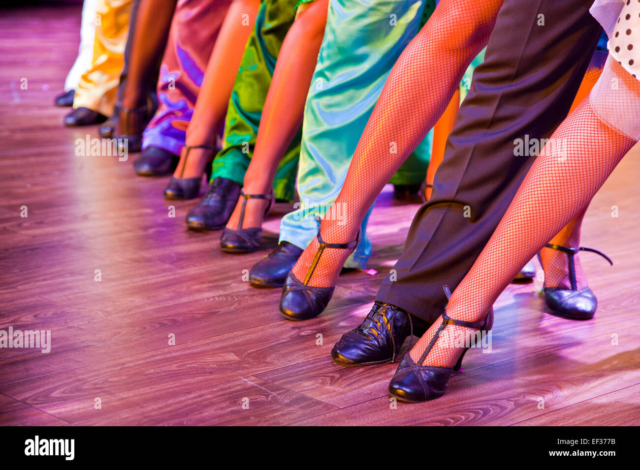 Gambe di ballerini sul palco indossando costumi colorati Foto Stock