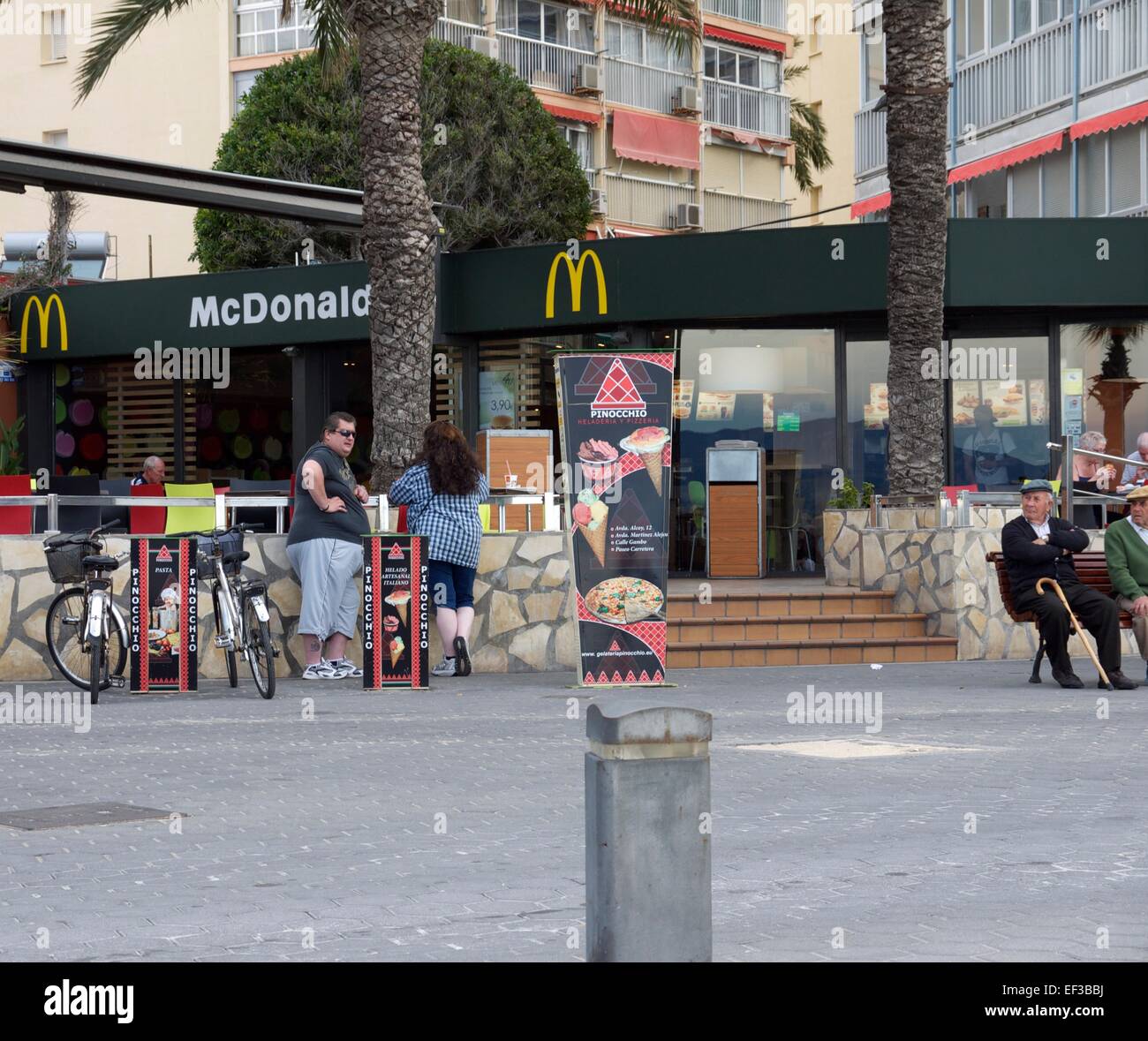 Due pesanti-set di persone al di fuori di un McDonalds in piedi da biciclette Foto Stock