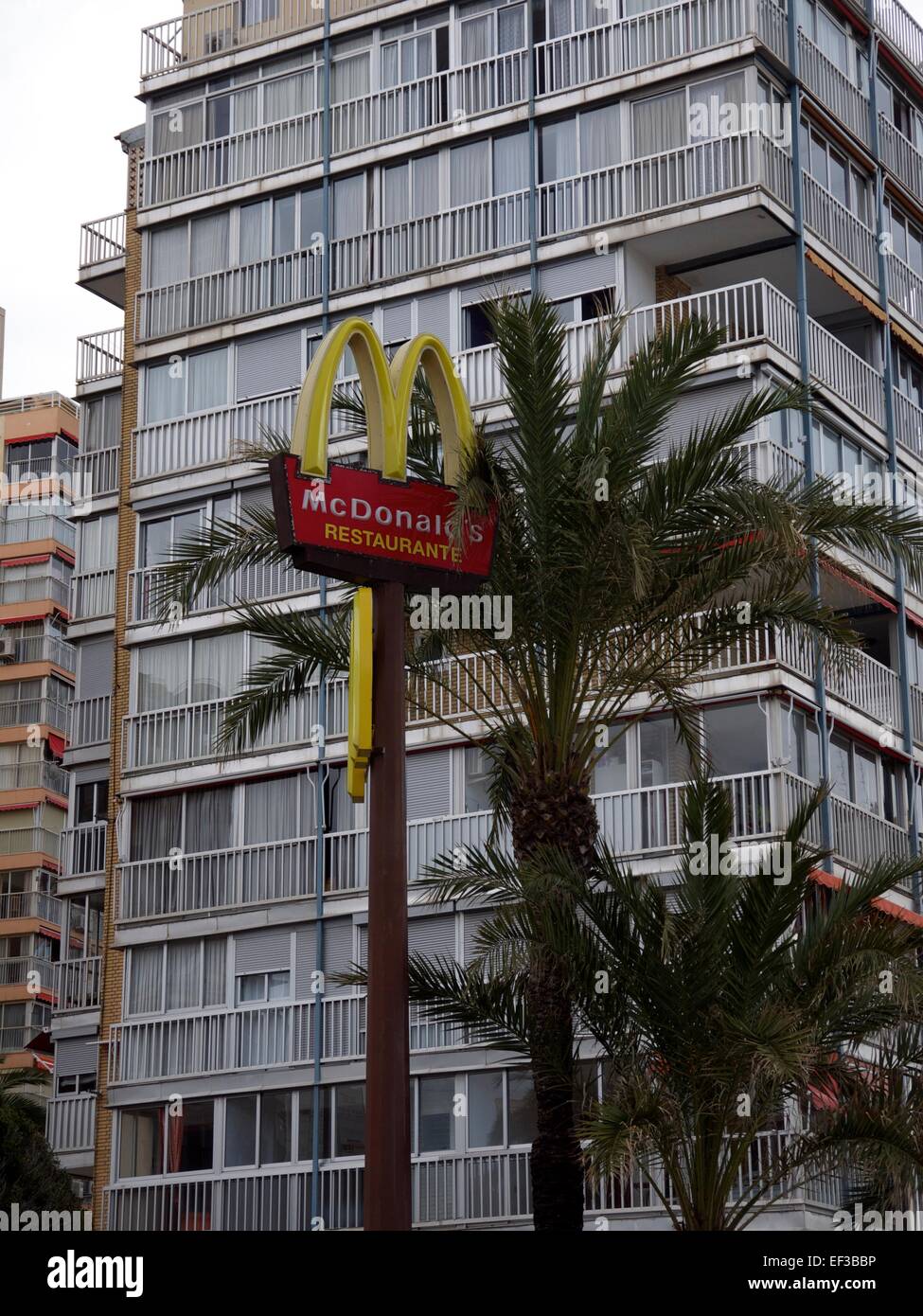 McDonalds segno davanti di palme e un edificio di appartamenti Foto Stock
