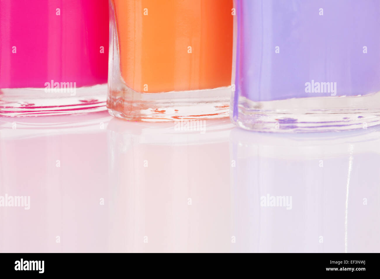 Tre multi-luminose colorate per unghie con la riflessione Foto Stock
