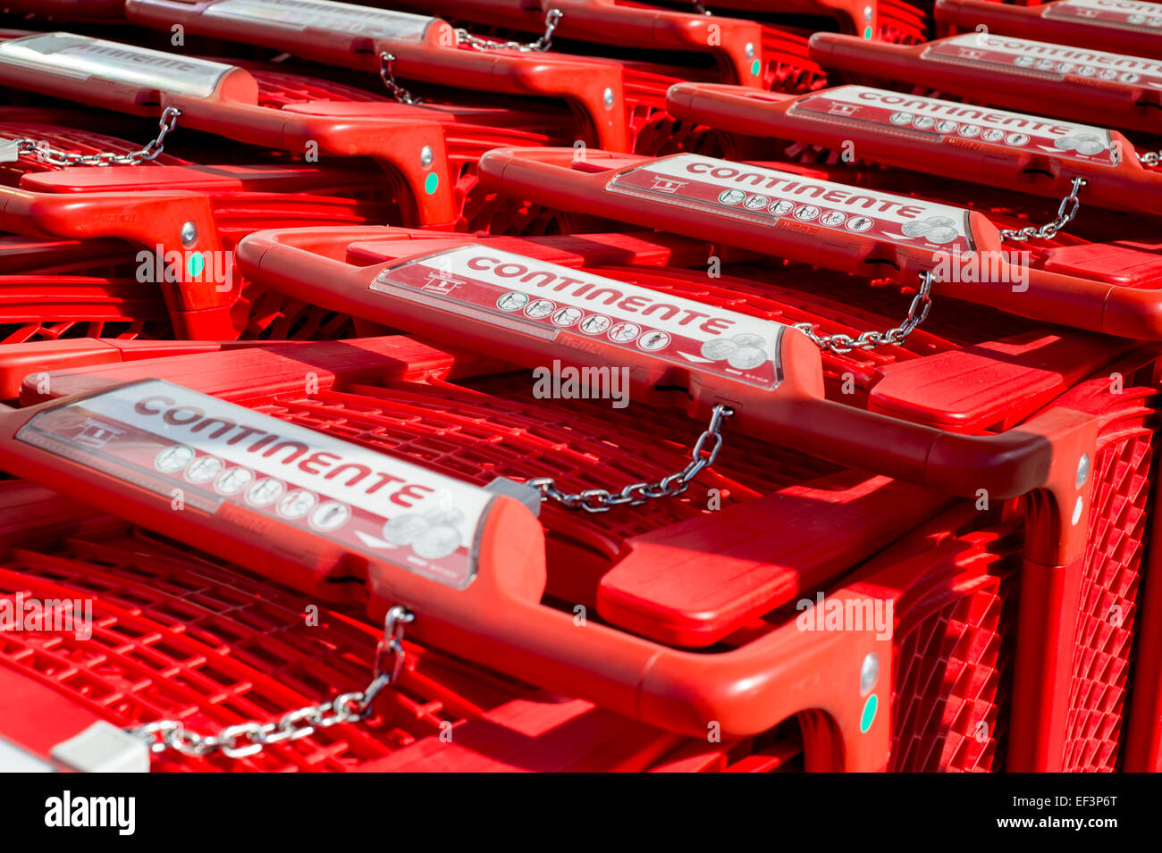 Red supermercato trollies con pay per il meccanismo di rilascio impilati insieme Foto Stock