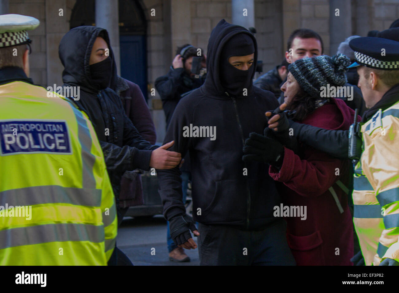 Il 24 gennaio 2015. Una mascherata protestor parla di un funzionario di polizia durante 'Wrap up Trident". Foto Stock