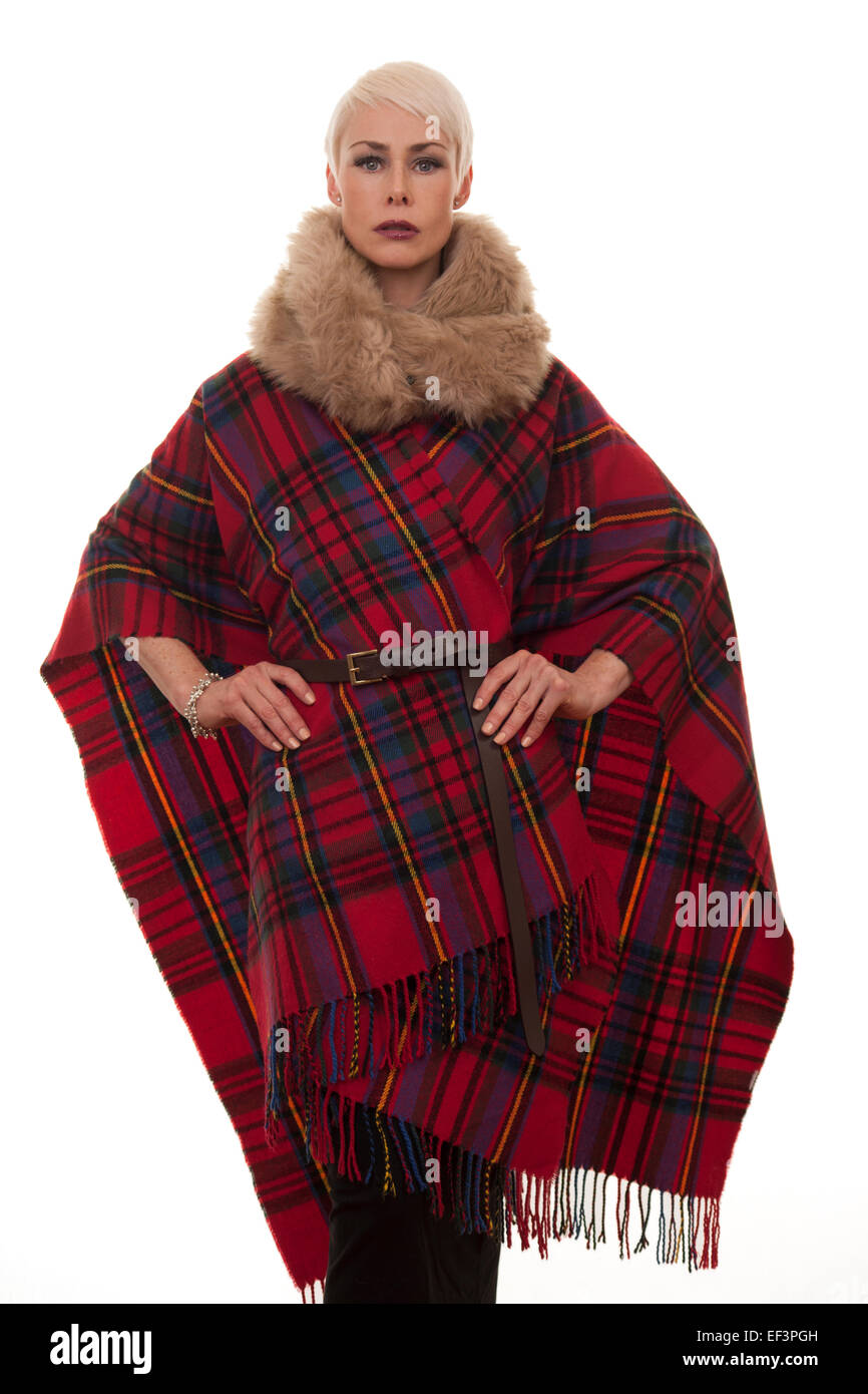 Donna matura indossando un blanket di tartan capo per mantenere in caldo Foto Stock