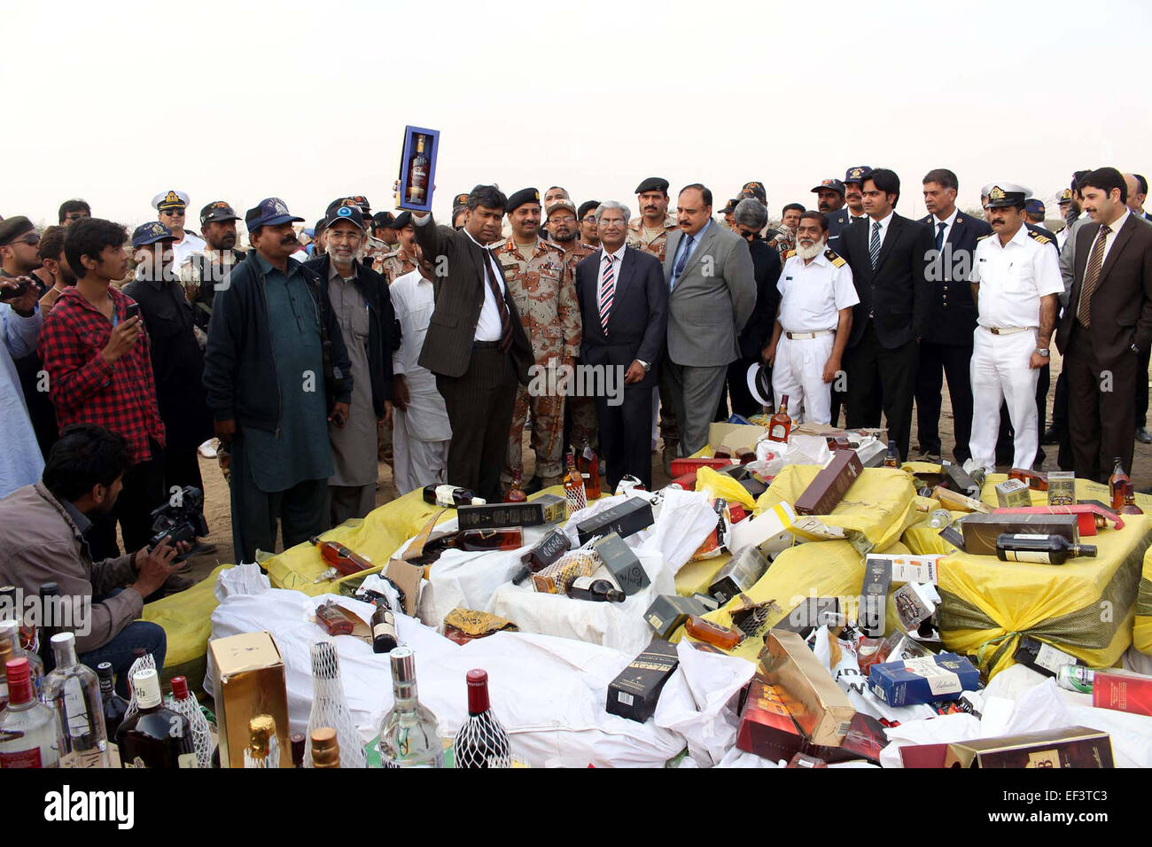 Karachi. 26 gen, 2015. Il pakistan i funzionari doganali stare accanto a sequestrate bottiglie di liquori e droghe per distruggere durante una cerimonia doganale internazionale giorno nel sud del Pakistan città portuale di Karachi il 7 gennaio 26, 2015. © Masroor/Xinhua/Alamy Live News Foto Stock