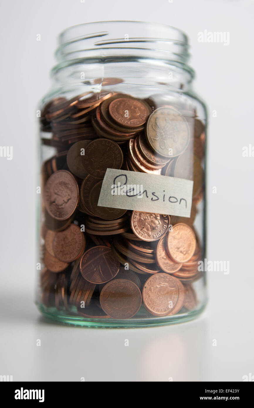 Un vaso di vetro azienda 1 e 2 pence monete con una etichetta dicendo "pensione". Foto Stock