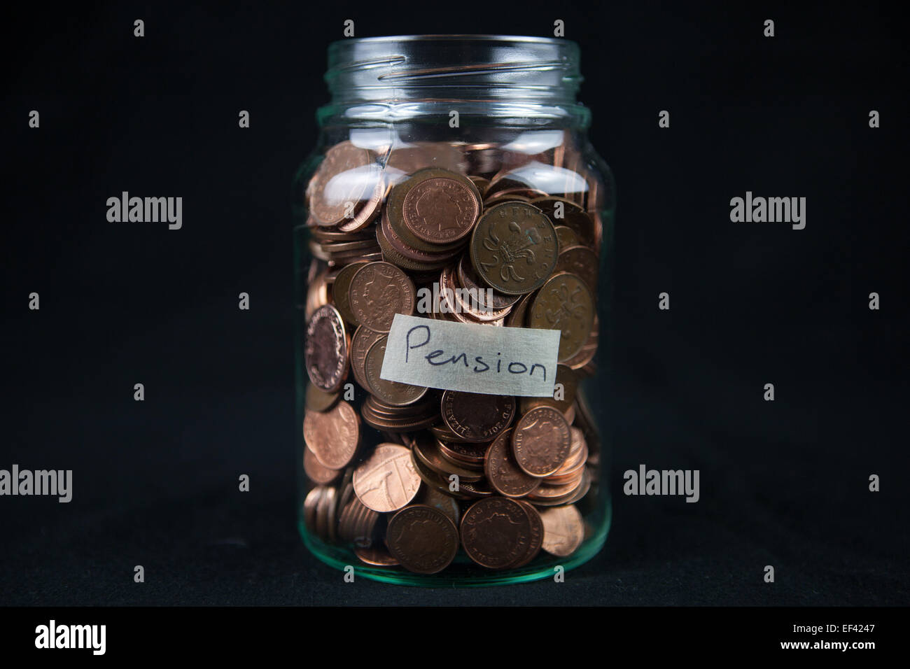 Un vaso di vetro azienda 1 e 2 pence monete con una etichetta dicendo "pensione". Foto Stock