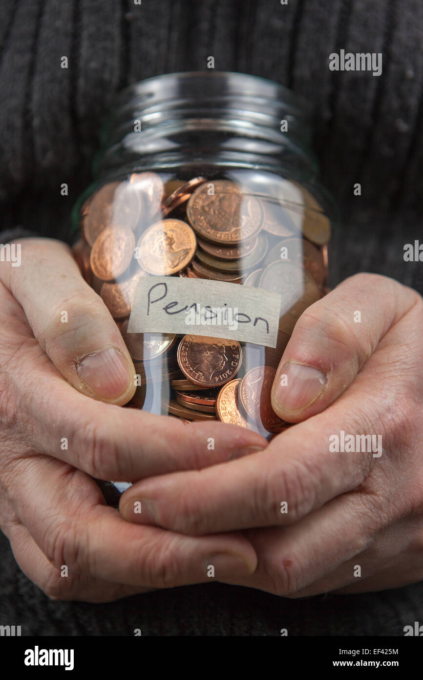 Un vecchio uomo stringendo una pentola di pensione in un vasetto di vetro. Foto Stock