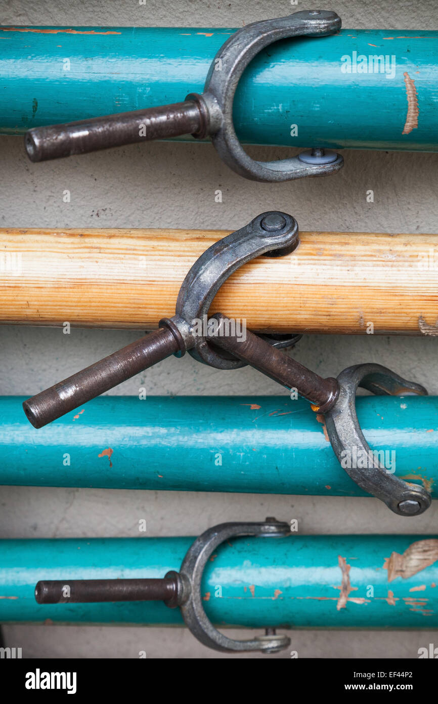 Gruppo di pale con forcole su grigio parete rurale Foto Stock