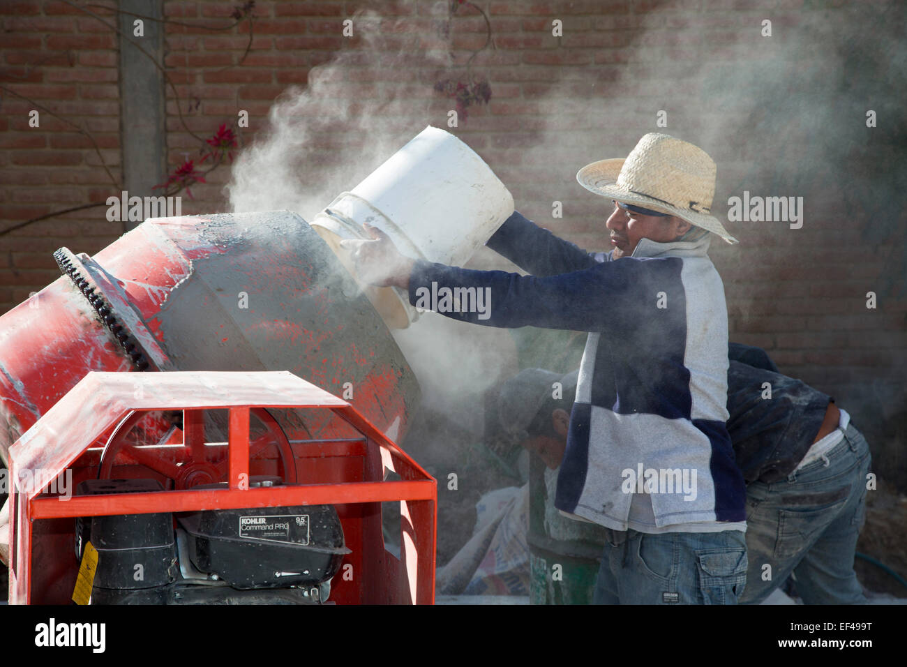 San Sebastian Abasolo, Oaxaca, Messico - Lavoratori cemento di miscela per preparare un ex via lo sporco in un piccolo borgo rurale del Messico. Foto Stock