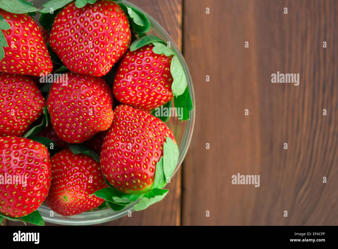 Vista dall'alto ciotola di fragole su legno Foto Stock