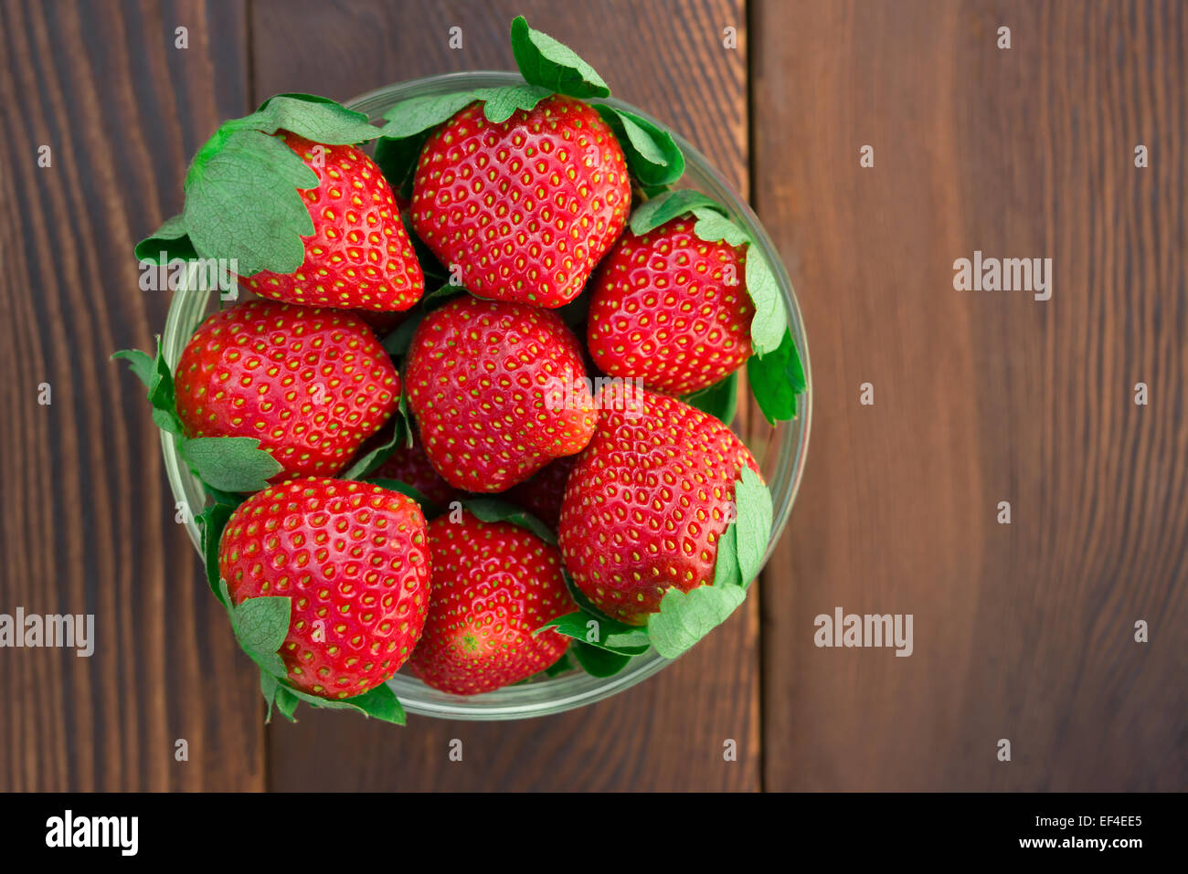 Vista dall'alto ciotola di fragole su legno Foto Stock