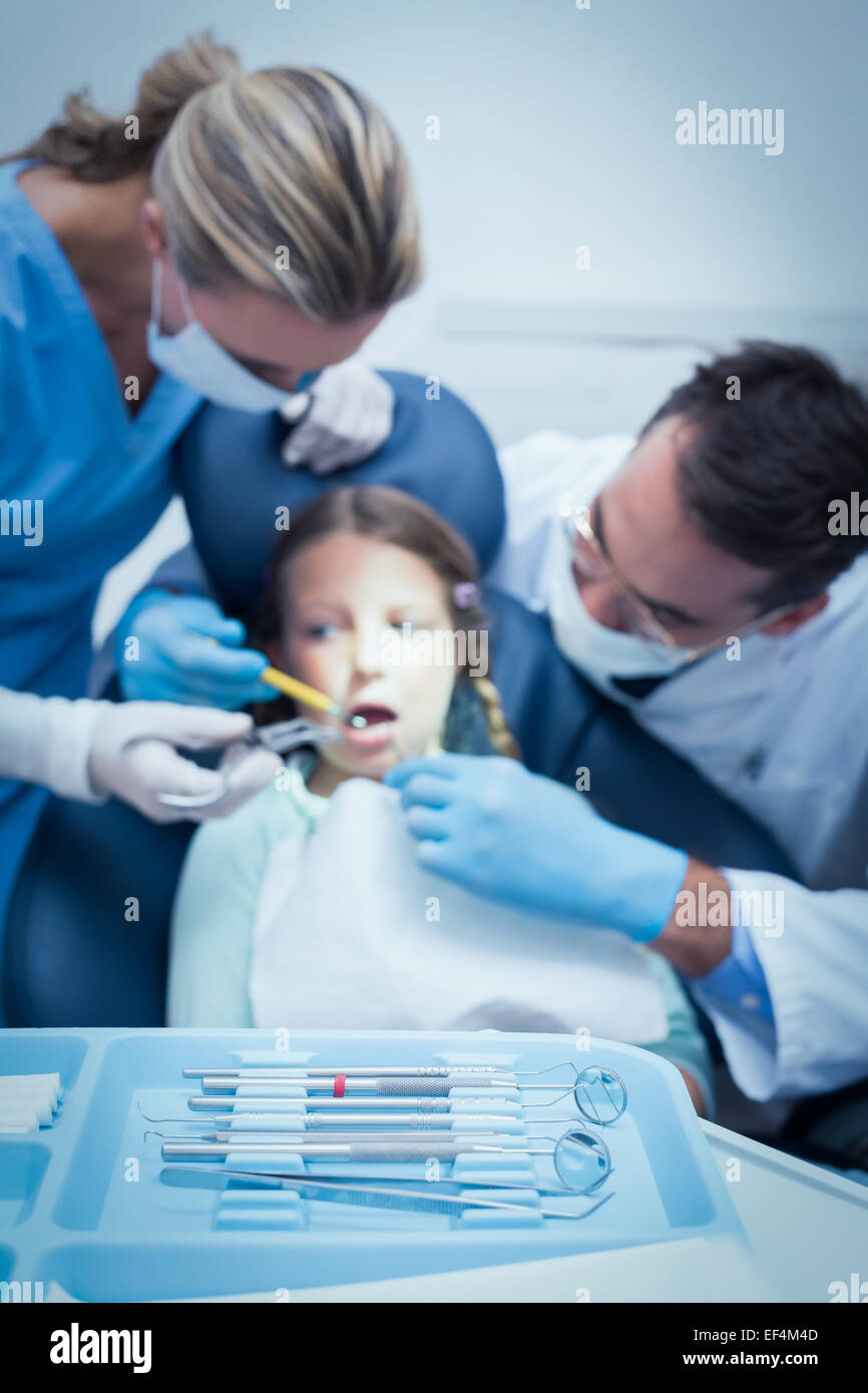 Dentista con assistente esaminando le ragazze denti Foto Stock