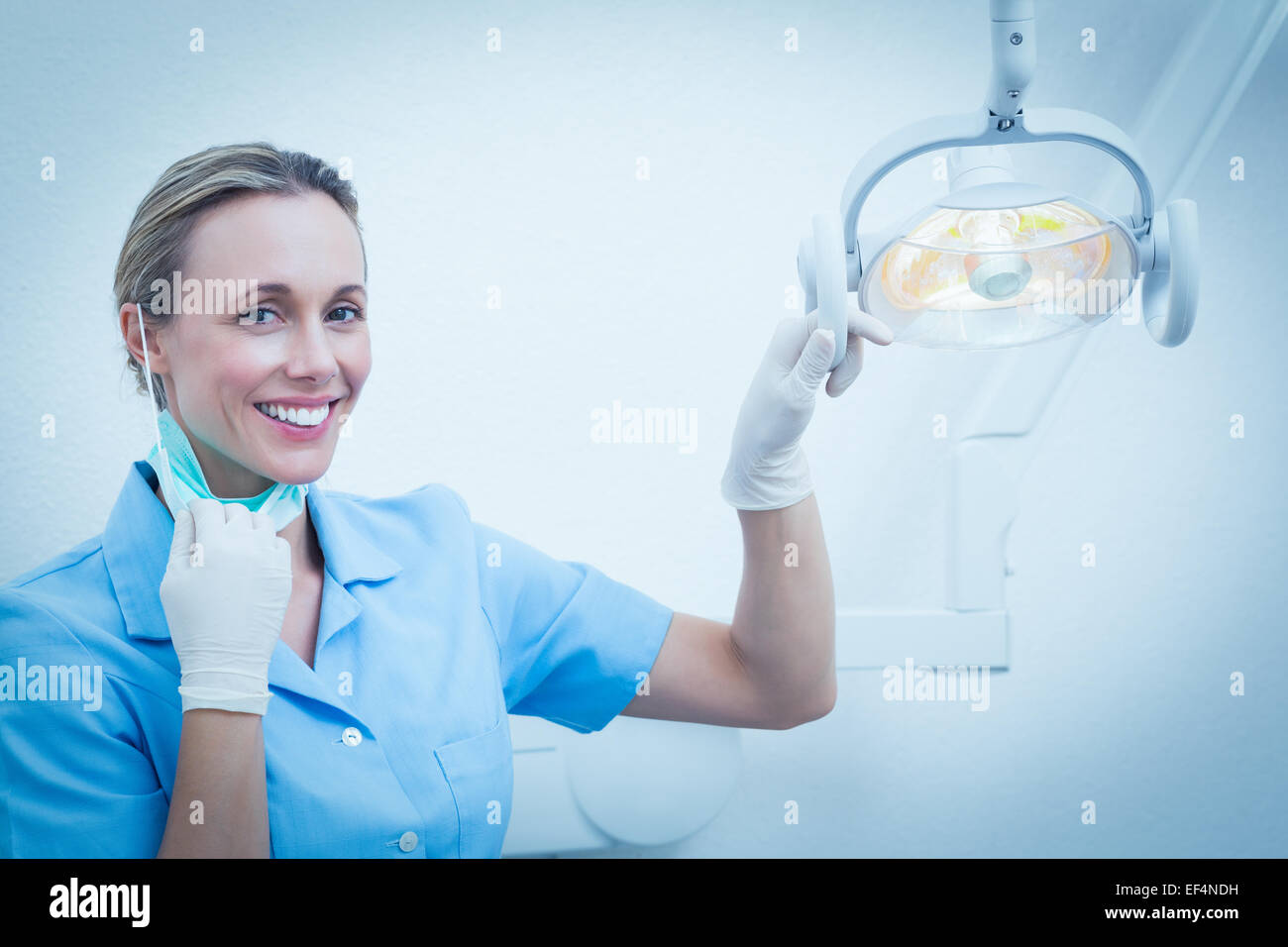 Donna sorridente dentista luce di regolazione Foto Stock