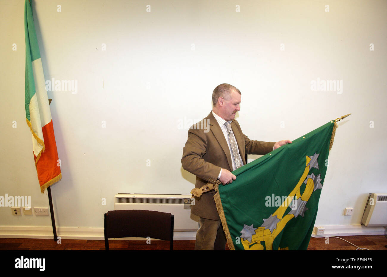 Ex INLA (Irish Esercito di Liberazione Nazionale) prigioniero Gerard Murray rulli fino un flag INLA in seguito ad una conferenza stampa dove il Foto Stock