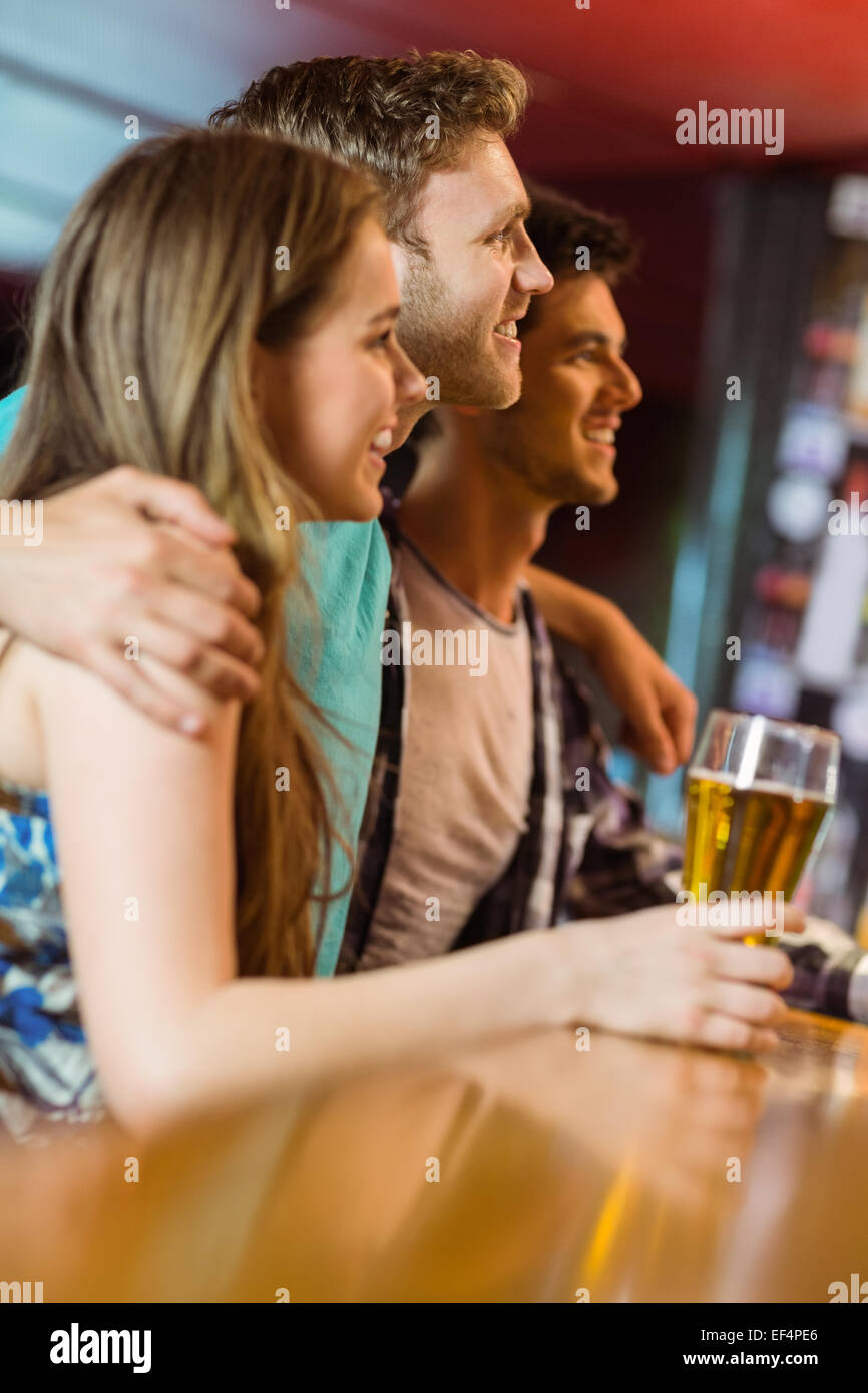 Sorridente marrone capelli in piedi con braccio intorno ai suoi amici Foto Stock Sorridente marrone capelli in piedi con braccio intorno ai suoi amici Foto Stock