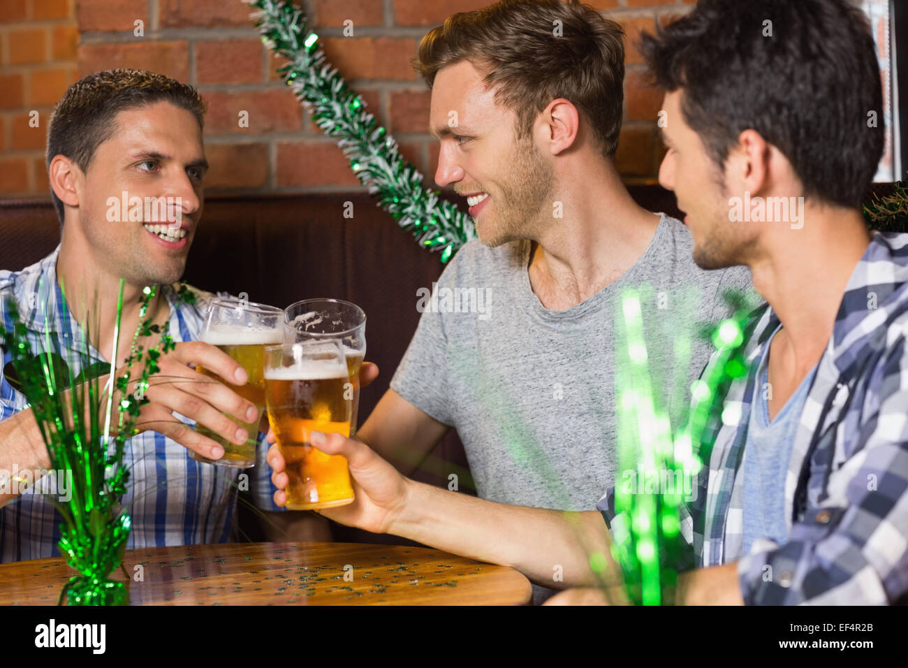 Happy amici bevendo pinte di birra su patricks giorno Foto Stock
