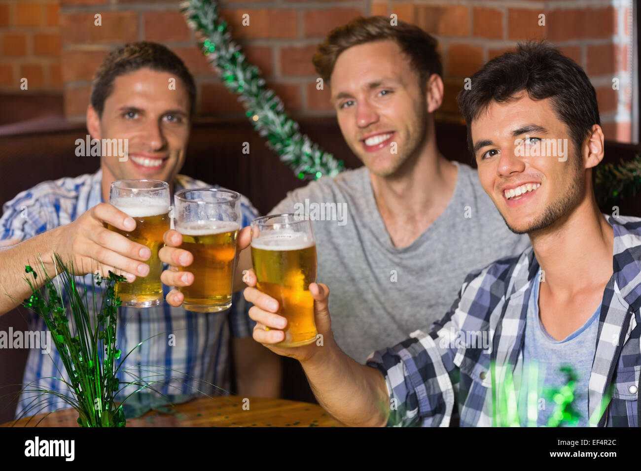 Happy amici bevendo pinte di birra su patricks giorno Foto Stock