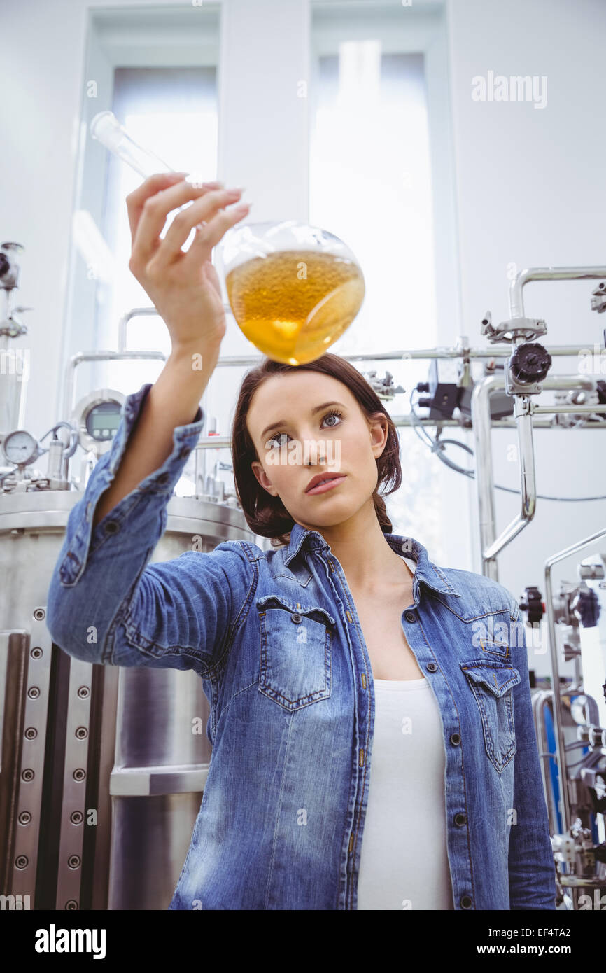 Elegante ragazza in camicia denim holding bicchiere di birra Foto Stock