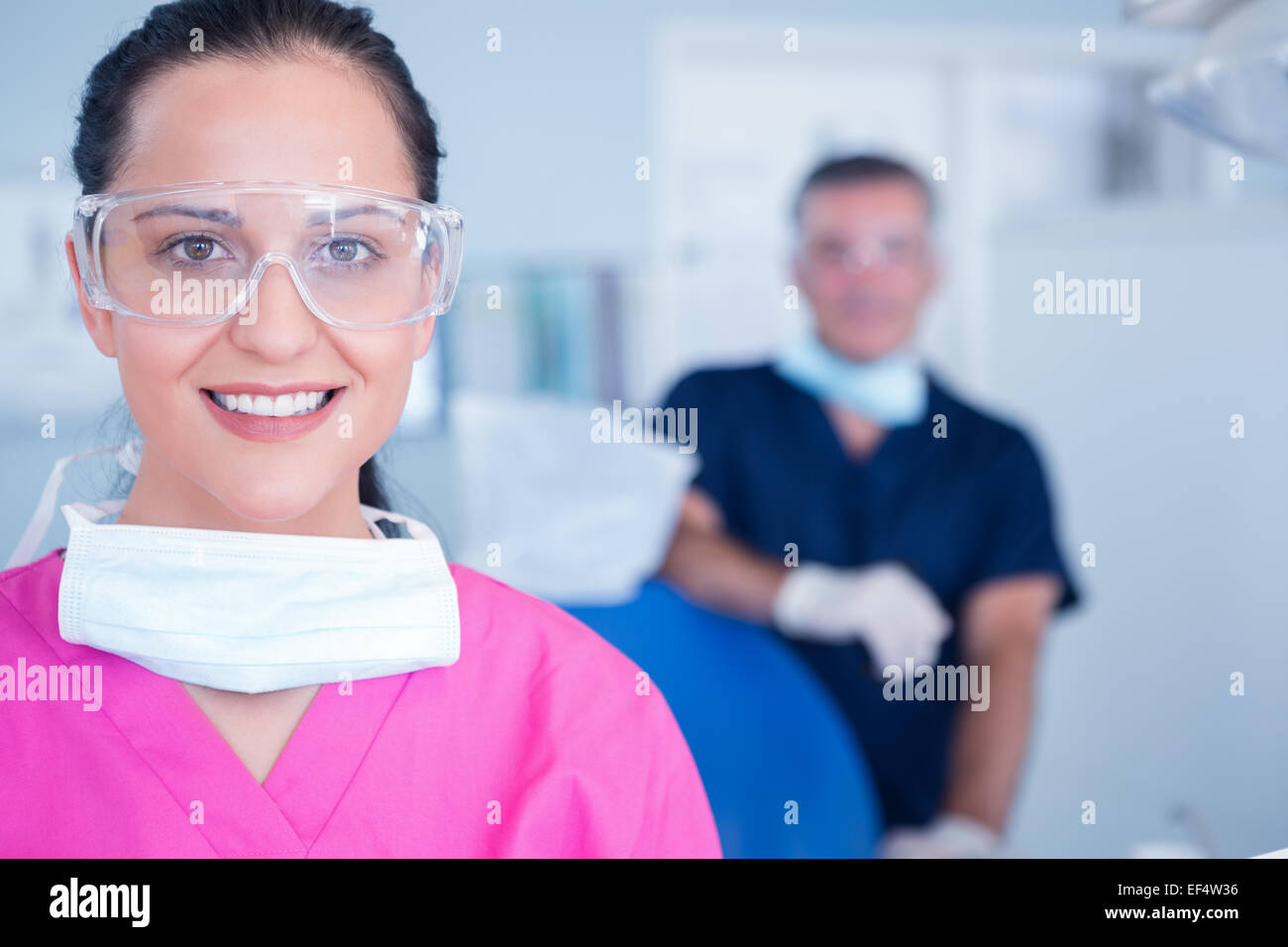 Assistente sorridente con gli occhiali di protezione Foto Stock