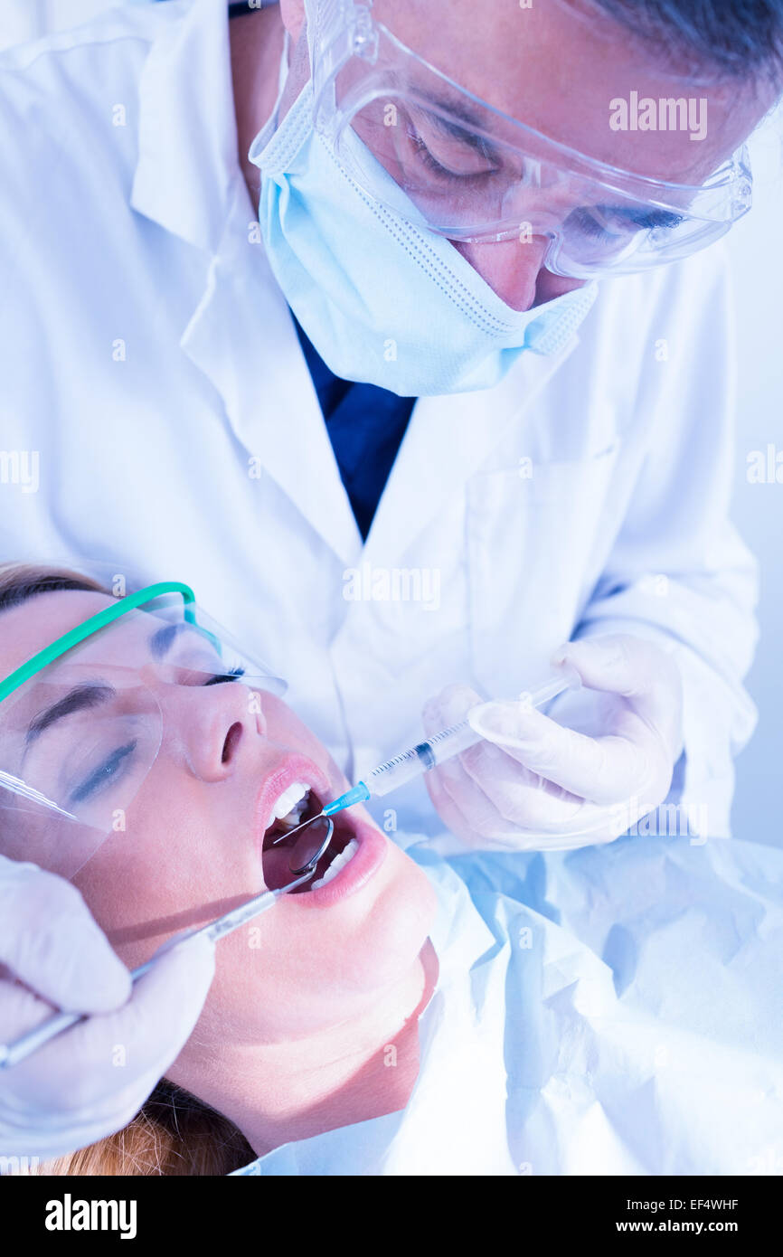 Il dentista di dare iniezione al paziente Foto Stock