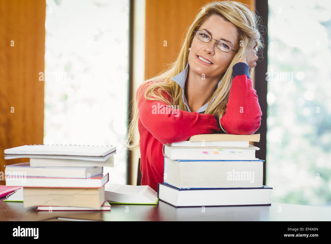 Sorridente studente maturo con la pila di libri Foto Stock