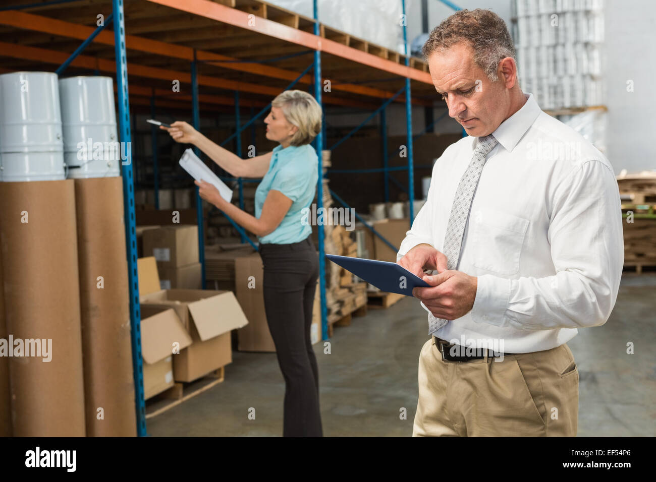 Sorridente warehouse manager utilizzando tablet pc Foto Stock