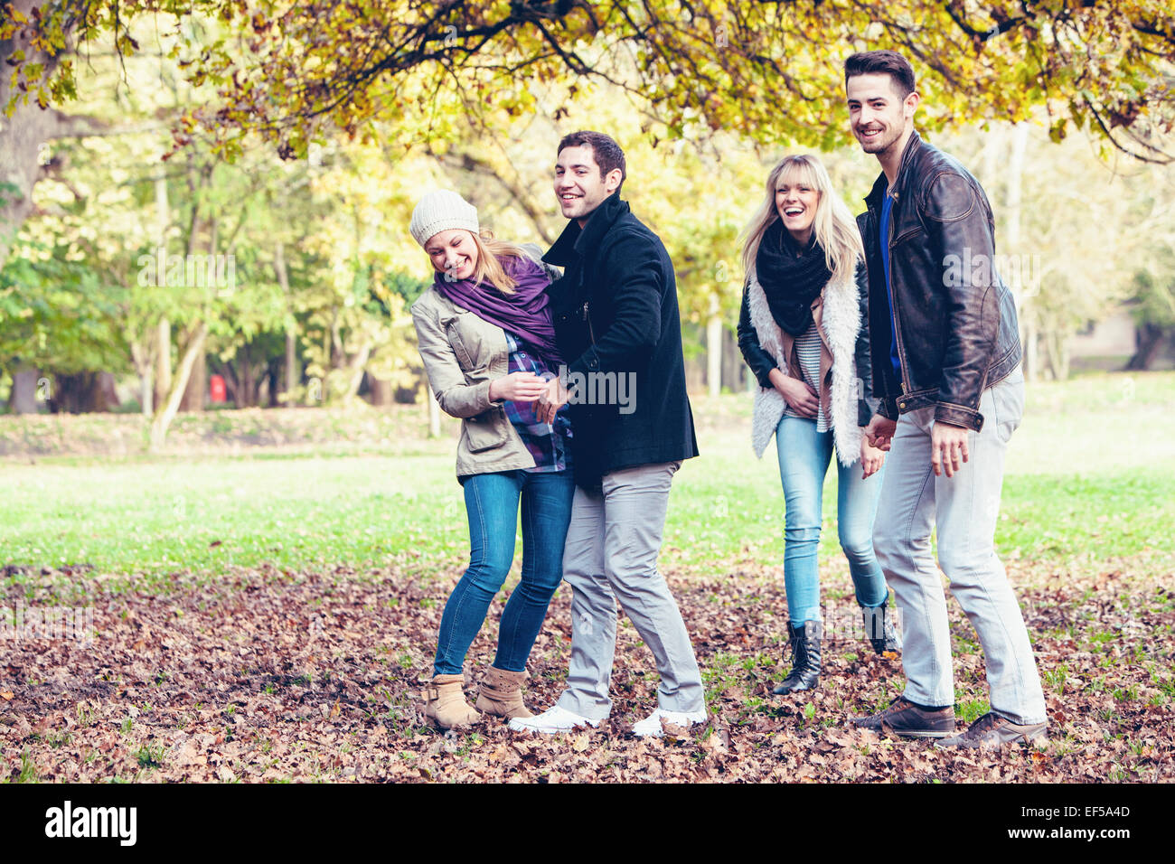 Gruppo di amici divertendosi in autunno park Foto Stock