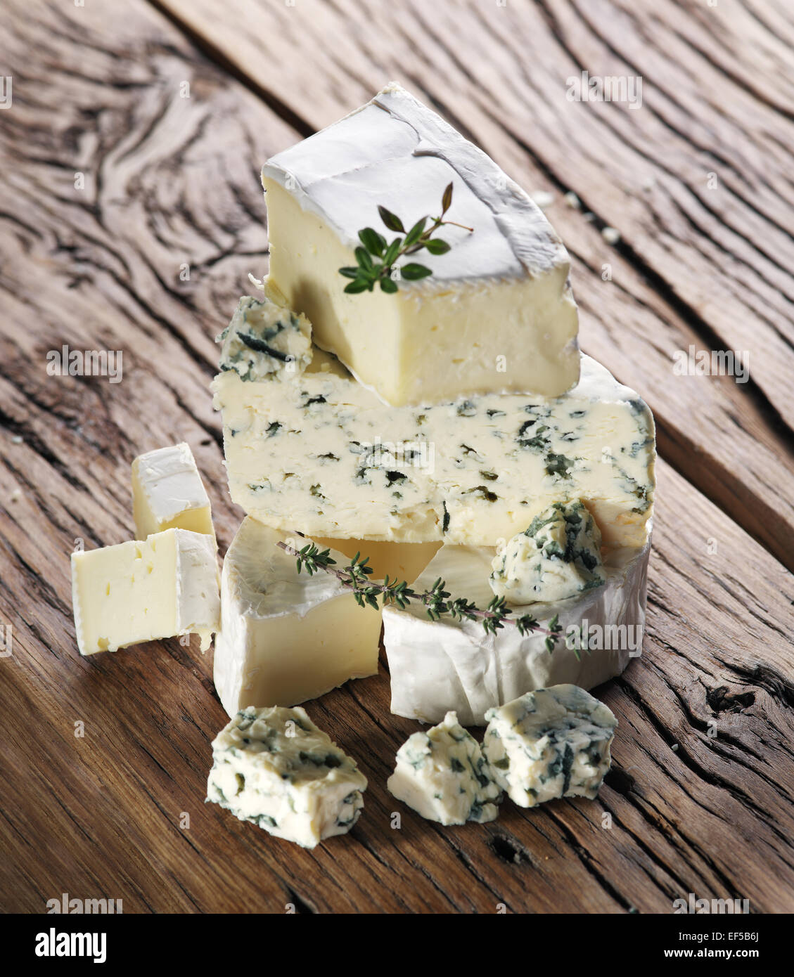 Gruppo di formaggio con stampo sul vecchio tavolo in legno. Foto Stock