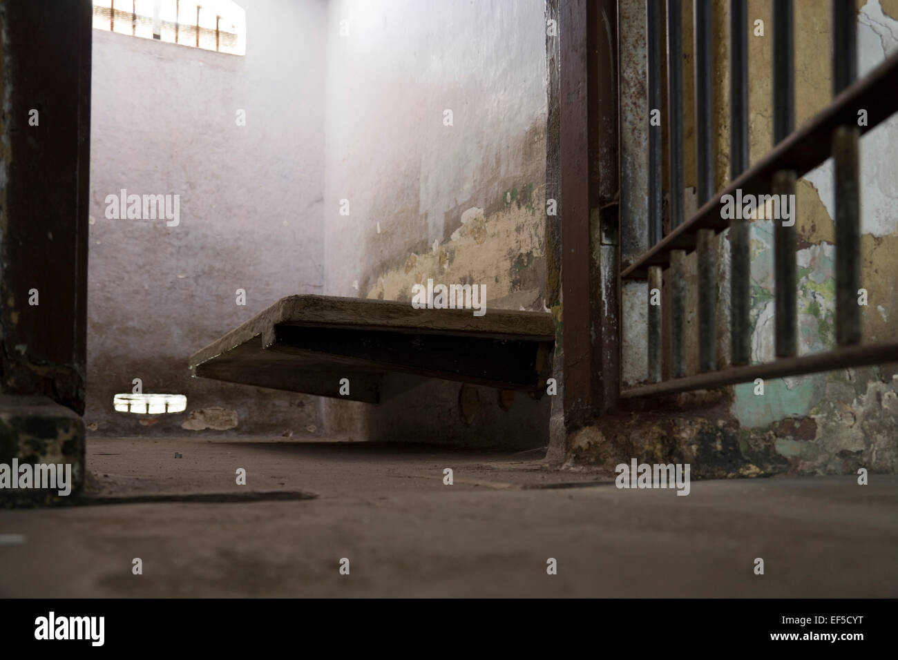 Cercando in una vecchia cella di prigione - calcestruzzo letto e molto piccola finestra, Malaysia Foto Stock