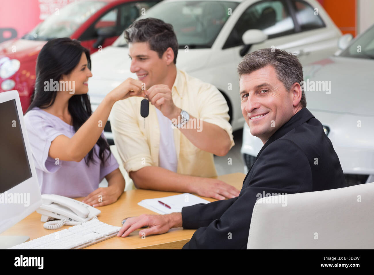 Sorridente giovane azienda la loro nuova chiave auto Foto Stock