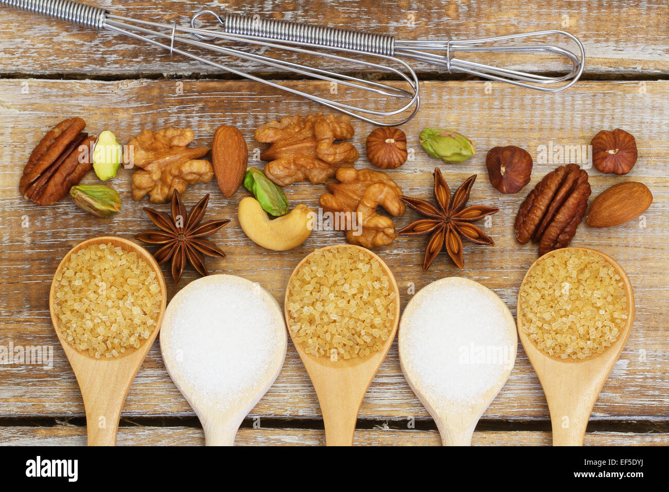 Zucchero, dadi e frusta rustico sulla superficie di legno Foto Stock