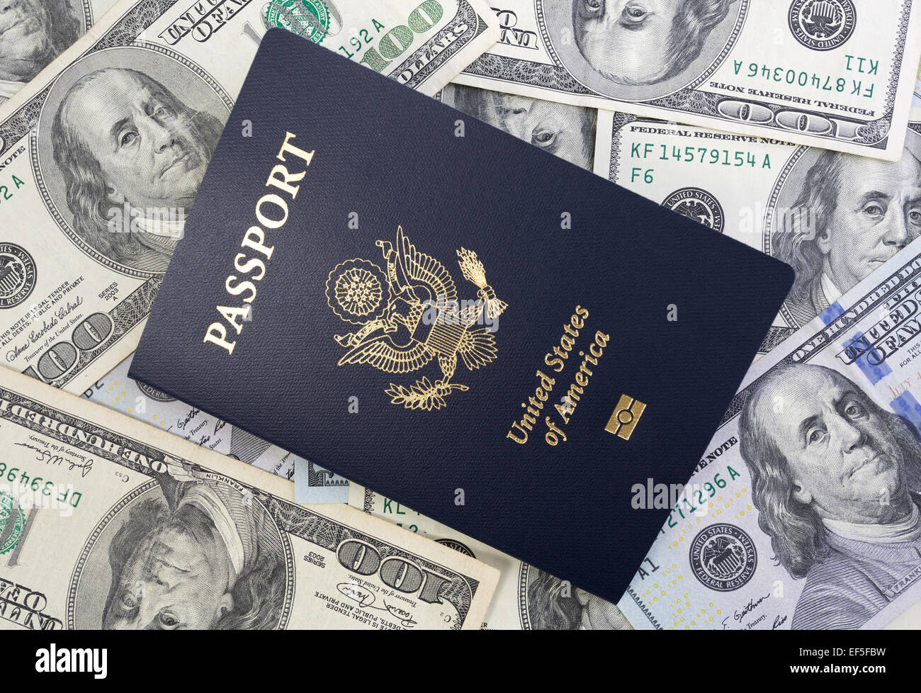 Gli Stati Uniti Passaporto sulla cima di una grande quantità di valuta degli Stati Uniti. Foto Stock