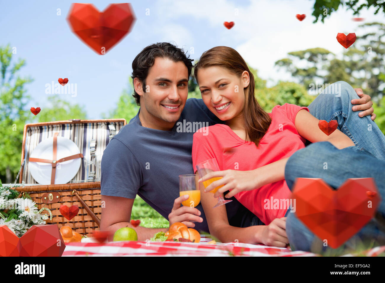 Immagine composita di due amici guardando avanti mentre essi detengono bicchieri durante un picnic Foto Stock