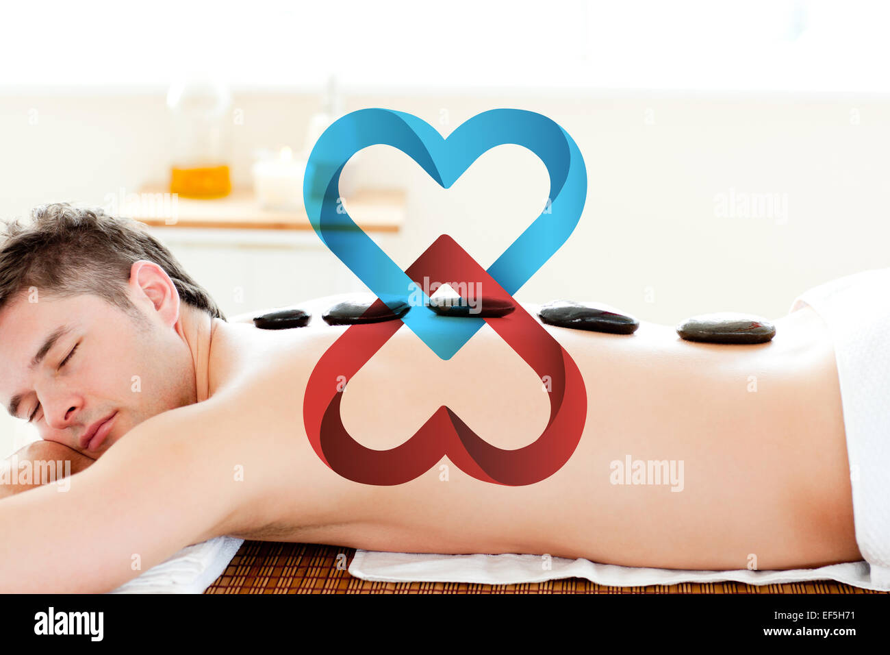 Immagine composita di rilassata man aventi con pietra calda sulla sua schiena Foto Stock