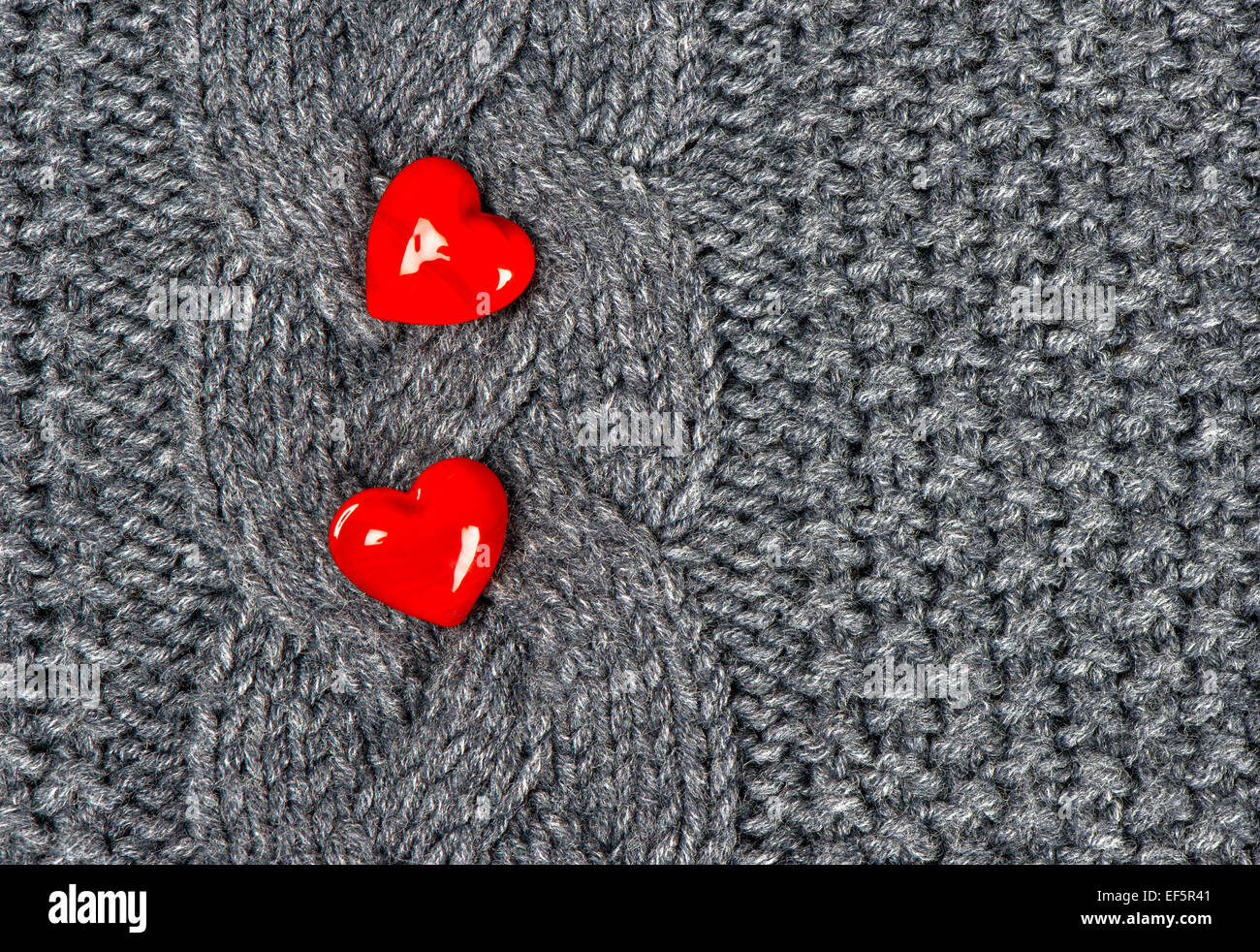 Due cuori rossi di maglia di lana lo sfondo Foto Stock
