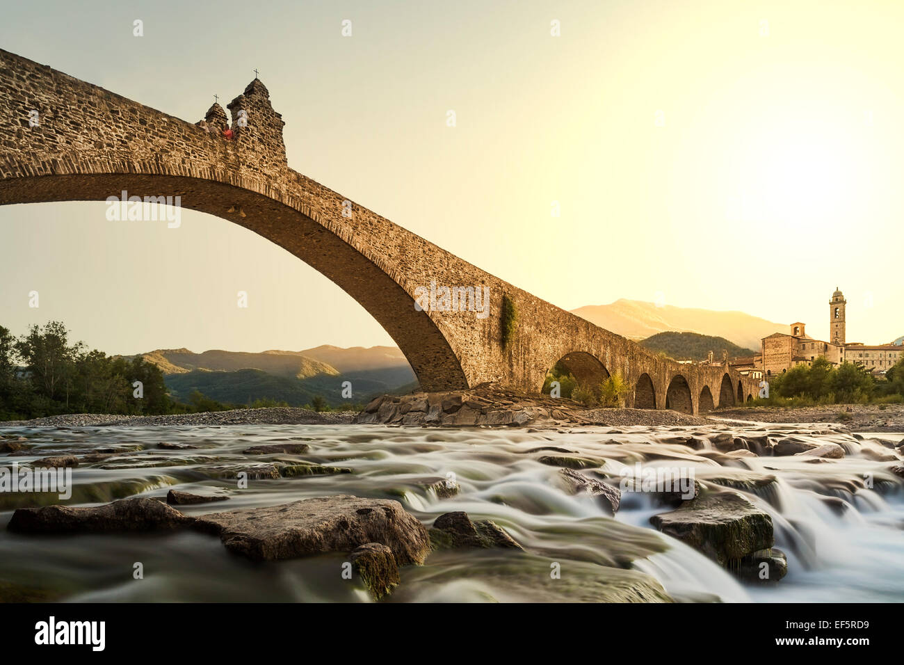 Gobbo bridge. Bobbio. Emilia Romagna. L'Italia. Il vecchio ponte "Gobbo" con i suoi archi sul fiume al tramonto. Foto Stock