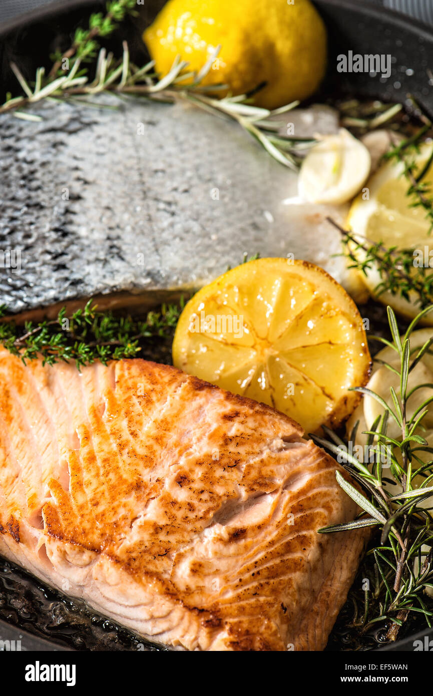 Salmone grigliato pesce con erbe aromatiche fresche, aglio e limone. Pesce sano Foto Stock