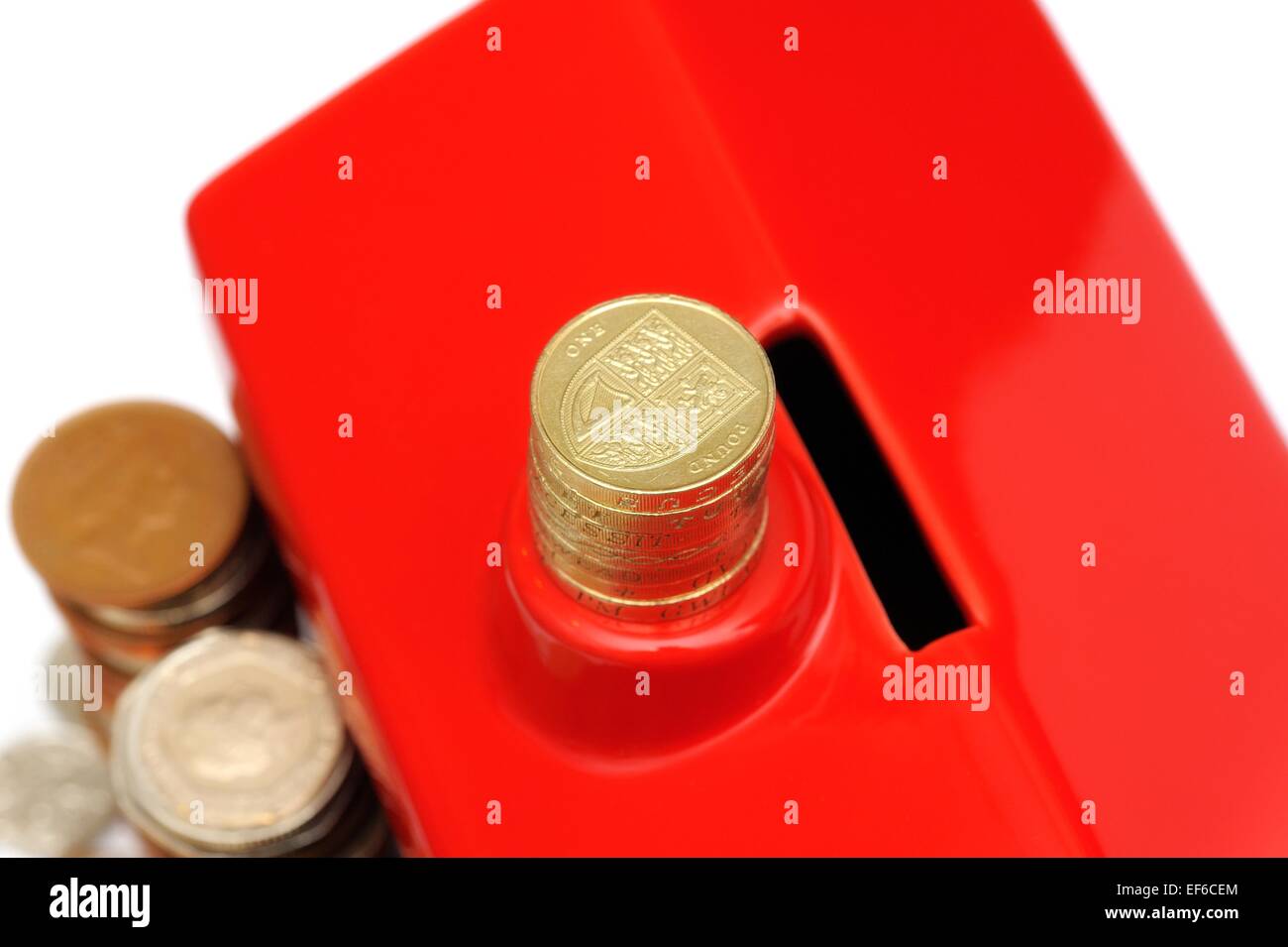 Una pila di una libbra di monete su un rosso scatola di denaro Foto Stock