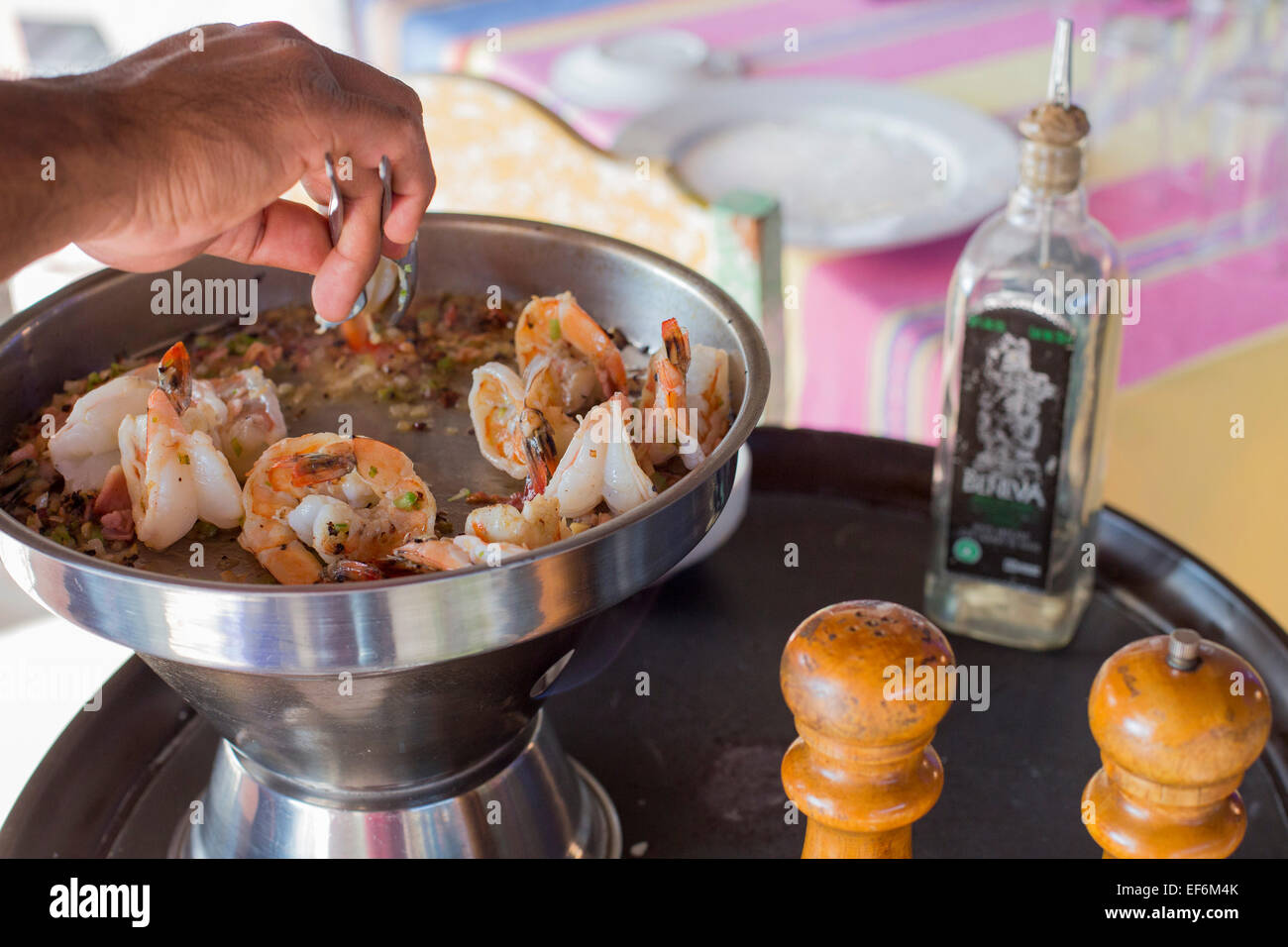 Mitla, Oaxaca, Messico - un cameriere cuochi di un piatto di gamberi con mezcal per diners a Restaurante Rancho Zapata. Foto Stock