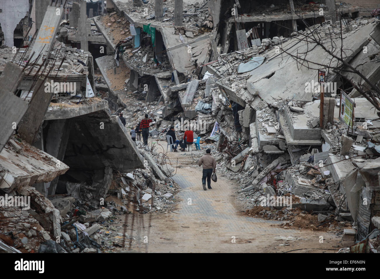 Gaza Gaza City. 27 gennaio, 2015. Palestinesi a piedi vicino alle loro case rocaille, che furono distrutti durante la 50-giorno offensiva israeliana sulla Striscia di Gaza negli ultimi mesi di luglio e agosto, nel quartiere Al-Shejaiya, a est di Gaza City, a gennaio 27, 2015. Soccorso e lavori delle Nazioni Unite (UNRWA) ha deciso il martedì a smettere di aiutare famiglie palestinesi le cui case sono state distrutte nell'offensiva israeliana scatenata contro la striscia di Gaza nel luglio e agosto dello scorso anno. © Wissam Nassar/Xinhua/Alamy Live News Foto Stock