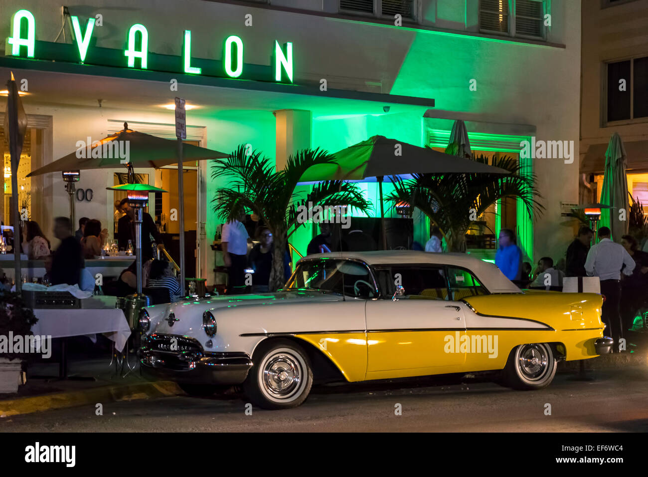 In due tonalità di giallo e bianco 1955 convertibile Olds Oldsmobile Super 88 hot rod e Avalon Hotel lungo Deco Drive, Miami Beach, Stati Uniti d'America. Foto Stock