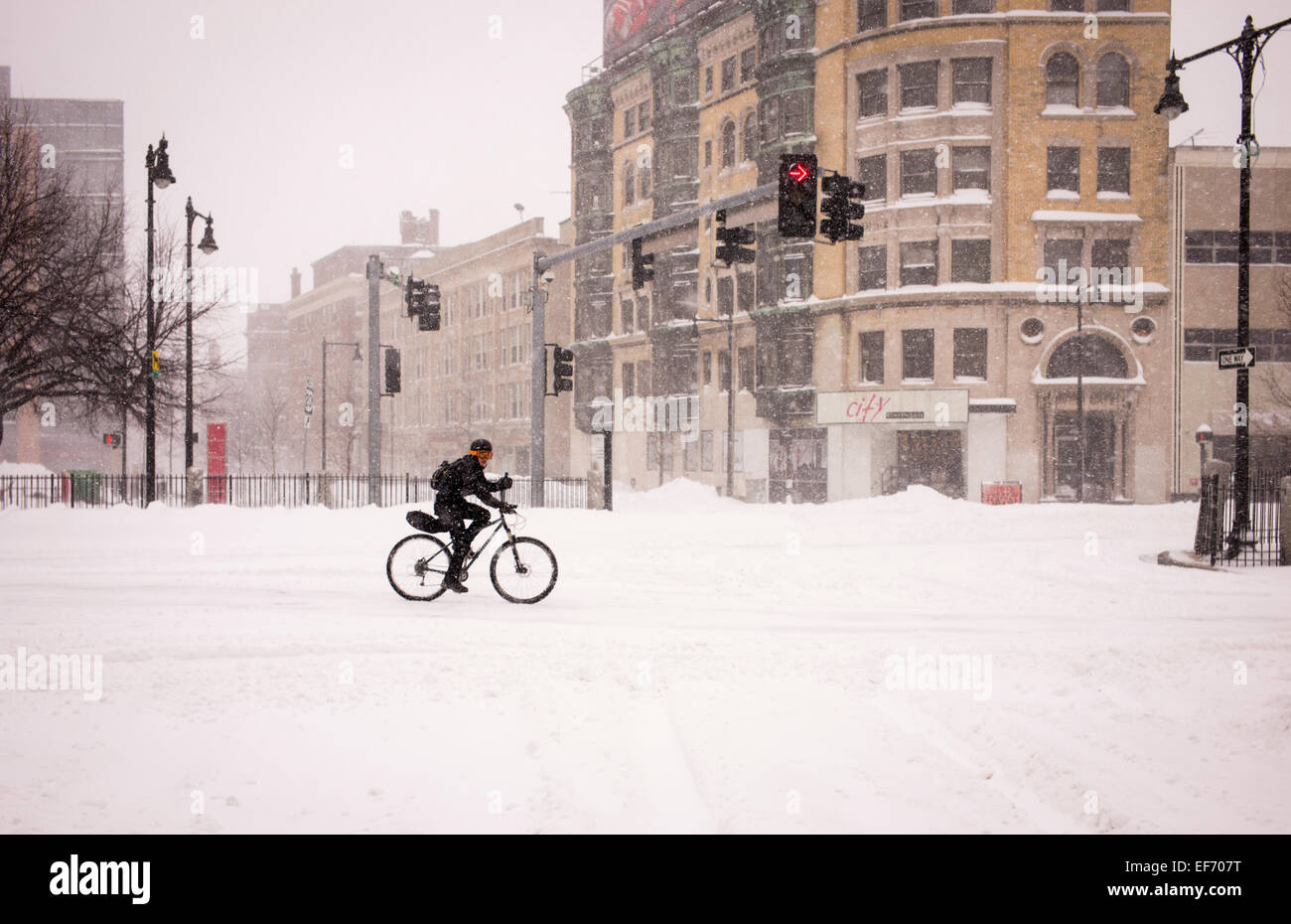 Un ciclista scorre su neve durante una bufera di neve a Kenmore Square nel centro cittadino di Boston. Foto Stock