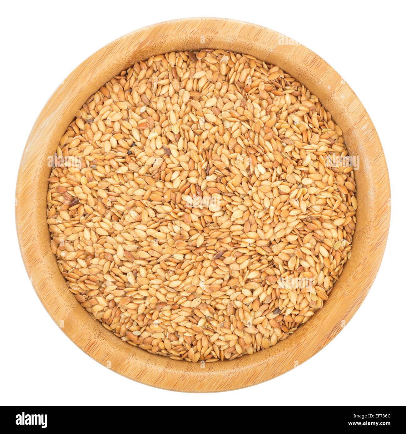 Golden semi di lino nella ciotola di legno isolato su sfondo bianco. Semi di lino sono ricchi in acido grasso omega-3. Vista dall'alto. Foto Stock
